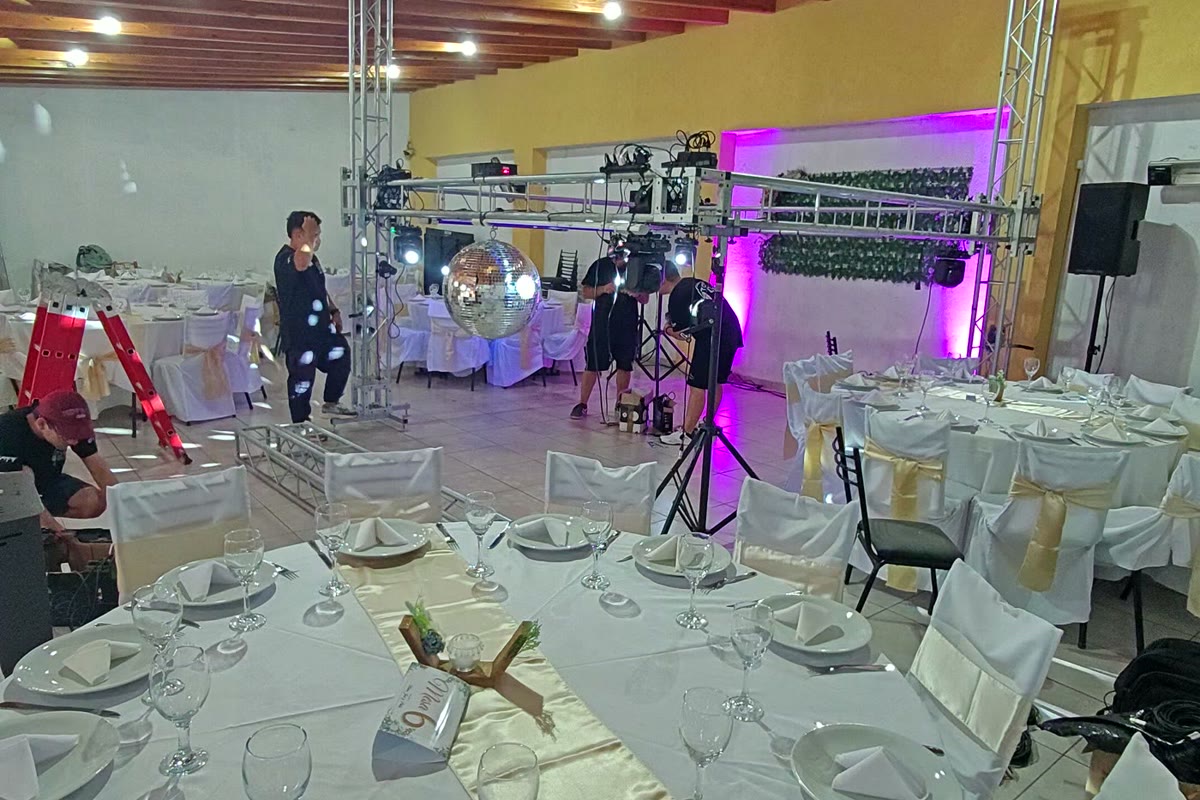 El equipo de Top Dj Group montando estructuras, luces y bola de espejos en el salón de un casamiento, horas antes de la fiesta