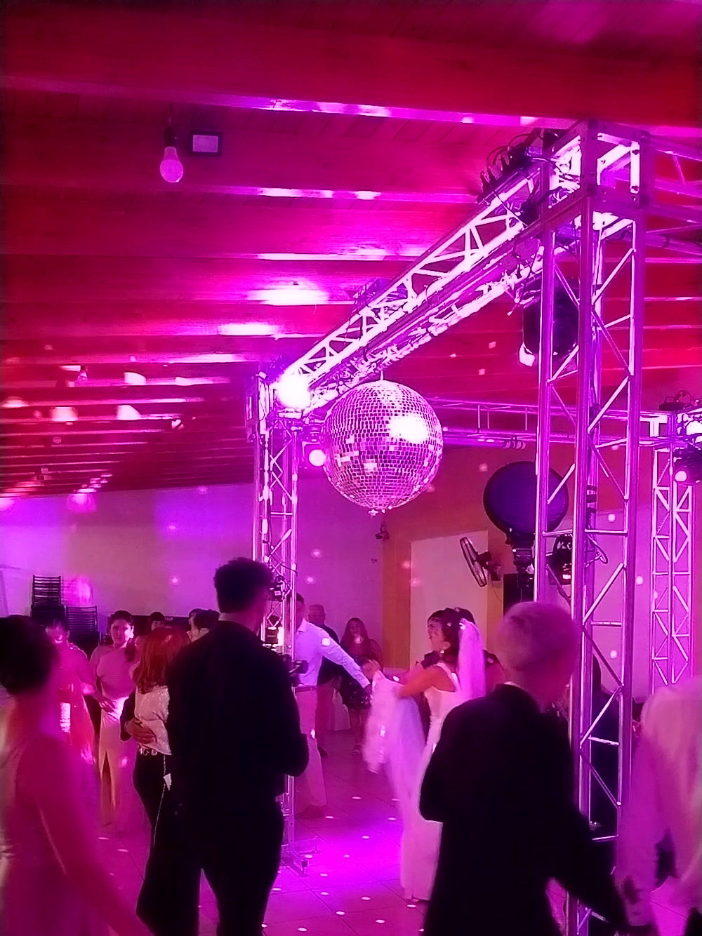 Pista llena bajo estructuras de luz y bola de espejos en una boda producida por Top Dj Group